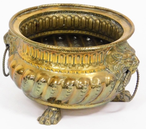 A Dutch brass lion mask bowl, with fluted body and lion mask handles with ring supports, on tripod claw feet, 15cm high, 12cm diameter.