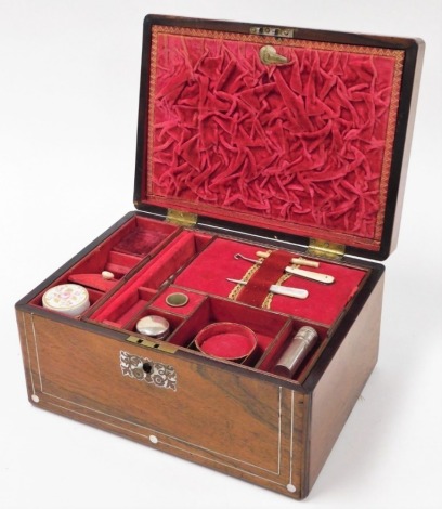 A 19thC oak and mother of pearl inlaid sewing box, the top with floral mother of pearl detailing, opening to reveal a crushed red velvet interior, with various compartments, silver topped jar, silver plated thimble, mother of pearl handled button hooks, e