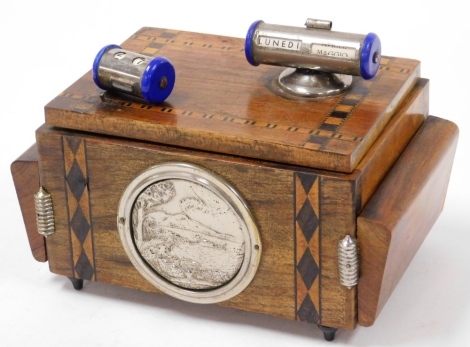 An Italian cigarette dispenser, the outer case with parquetry banding and applied top steel dial, and date, with central mirror layered design, and a shield in pewter marked with a seascape, 15cm high, 22cm wide, 12cm deep.