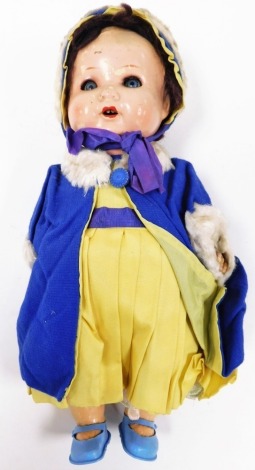 An Armand Marseille bisque headed doll, numbered 518042, with painted face and limbs, in a blue and yellow dress, 31cm high.