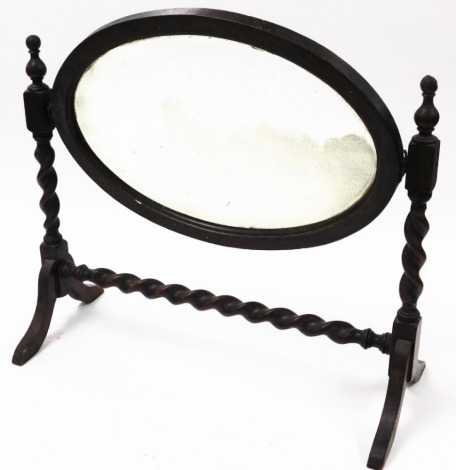 An oak barley twist dressing table mirror, with oval central mirror plate, on two barley twist column supports, 55cm high, 62cm wide.