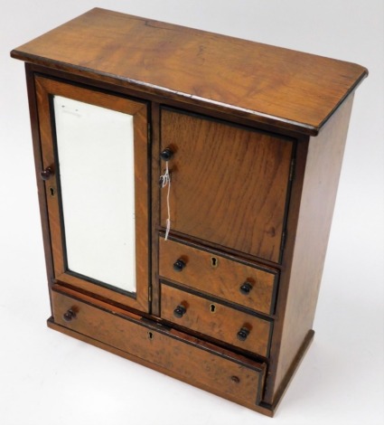 An oak smoker's cabinet, with single glazed door with tobacco cupboard section above three drawers, 44cm high, 35cm wide, 18cm deep. (AF)