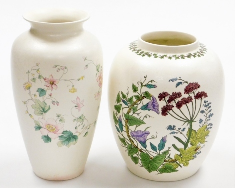 Two Poole pottery vases, to include one with blue bell design, signed G Breeze, and another taller stem vase with pink daisies, 21cm and 27cm high.