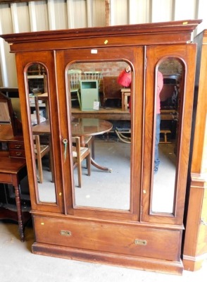 A Victorian mahogany double wardrobe, with central mirrored door and two small panelled mirrored doors, on a drawer base with block feet and cornice.