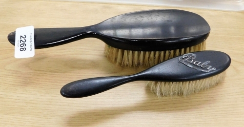 A part dressing table set, with ebony backed handles, and one small brush inscribed Baby with silver label. (2)