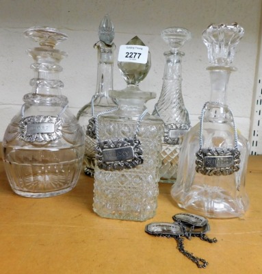 Five cut and pressed glass decanters, each with silver plated decanter label.