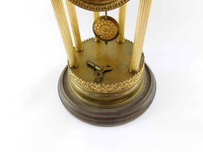 A continental brass mantel clock, the circular dial with silvered Arabic numerals, eight day movement striking on a bell, the case of temple form with six fluted columns, under a glass dome, with key, 38cm high. - 13