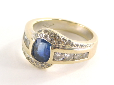 A sapphire and diamond dress ring, with oval sapphire in rub over setting, approx 1.43cts, white diamond set twist shoulders, with four round brilliant cut diamonds in tension setting, white metal, marked 750, ring size P½, 11.1g all in.