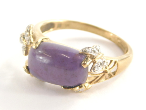 A 9ct gold dress ring, set with central purple rectangular cut stone, with butterfly details set with tiny diamonds, with pierced X frame shoulders, ring size U, 4.5g all in.