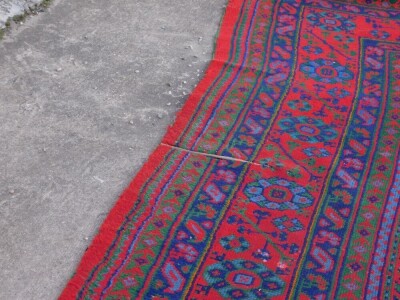 A large Turkish carpet, decorated with flowers, roundels, etc., in pale blue, navy and green, on a red ground with multiple borders, 440cm x 392cm. - 3