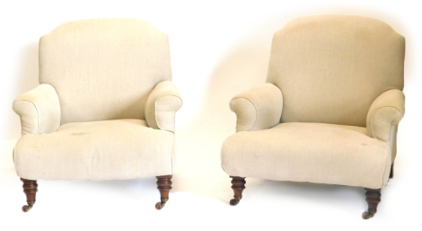 A pair of Victorian walnut Howard type armchairs, each upholstered in beige fabric and turned legs with ceramic castors, number stamped to rear legs.