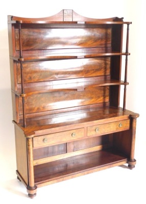 A mid 19thC figured mahogany whatnot cabinet, with a raised back above three shaped shelves, each on cylindrical turned supports, the base with two frieze drawers above a recess, on turned pillars with bun feet, 159cm high, 122cm wide.
