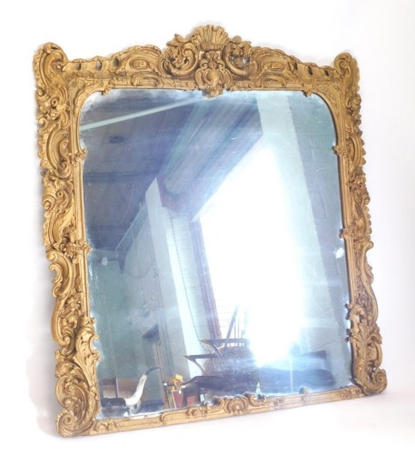 A 19thC gilt gesso overmantel mirror in Rococo style, decorated with scrolls, flowers, leaves surrounding a central shell, (AF), 151cm high, 135cm wide.