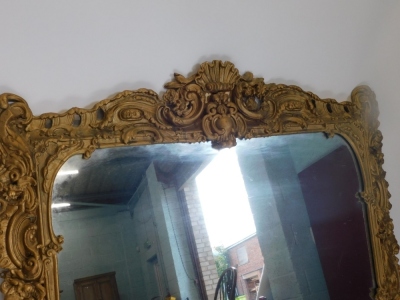 A 19thC gilt gesso overmantel mirror in Rococo style, decorated with scrolls, flowers, leaves surrounding a central shell, (AF), 151cm high, 135cm wide. - 2