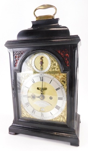 John Richardson, London. A George III ebonised bracket clock, the arched dial with silver chapter ring engraved with Roman numerals, gilt rococo scroll spandrels and strike silent subsidiary, the case with fret panels to the doors, canted corners on block