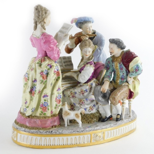 A late 19th/early 20thC continental porcelain figure group, modelled in the form of musicians around a piano with a small dog, picked out in coloured enamels, indistinctly cross swords type mark to underside, 33cm wide.