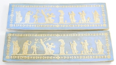 A pair of 19thC pale blue Jasperware plaques, each decorated with Neo Classical figures, trees, putti, etc. within oak leaf and acorn border, possibly Wedgwood, marks obscured, 46cm x 15cm.