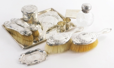 An Art Nouveau design silver dressing table set, comprising a large rectangular tray, decorated in typical Art Nouveau style with flowers, scrolls, etc., initialled D in the central cartouche, 31.5cm x 23cm, 18½oz, two silver backed hairbrushes and two cl