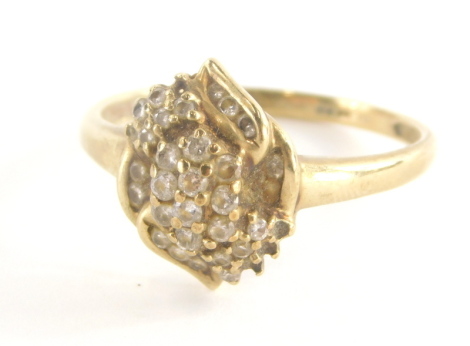 A 9ct gold dress ring, with central cross over floral detailing set with cz stones, in claw and tension settings, marked QVC, ring size T, 2.5g all in.