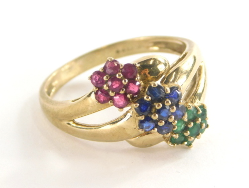 A 9ct gold dress ring, set with three layered design of flowers, with emeralds, rubies and sapphires, ring size S, 3.8g all in.