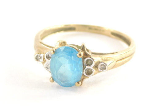 A 9ct gold dress ring, with pale blue oval topaz, in four claw setting, with stepped three stone cz shoulders, on a yellow metal band, marked QVC, ring size V, 2.6g all in.