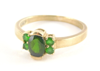 A 9ct gold dress ring, with central oval cut peridot, flanked by four peridots, each in claw setting, marked QVC, ring size S½, 2.6g all in.