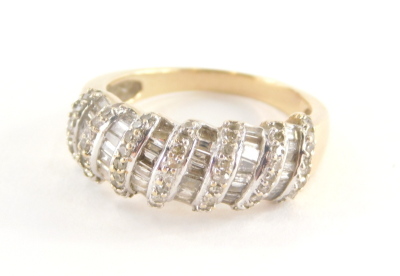 A diamond set dress ring, of half hoop design, with seven rows of round brilliant cut diamonds and six rows of baguette cut stones, in a white gold coloured setting on a yellow metal band, unmarked, believed to be 18ct gold, ring size O½, 5.1g all in.