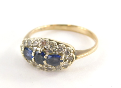 A 9ct gold sapphire and diamond dress ring, the oval ring head set with oval cut sapphires, in a white gold setting, with surround of round brilliant cut diamonds, on a yellow metal band, hallmarks rubbed, ring size S½, 3.5g all in.