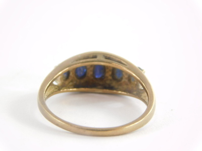 A dress ring, set with five oval cut dark blue faceted stones, pierced and oval setting on a yellow metal band stamped 9ct QVC, 3.3g all in. (AF) - 2
