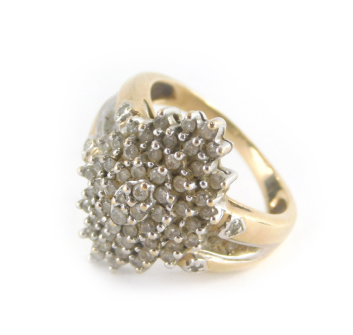 A dress ring, with central cluster design with cz stones and shoulders, on a yellow metal band unmarked believed to be 9ct, ring size Q, 7.2g all in.