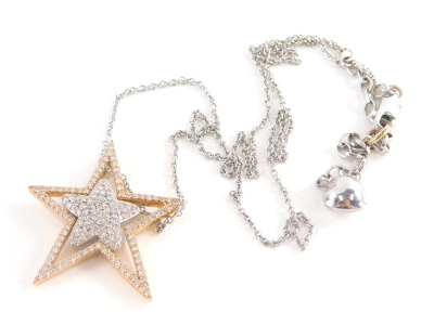 A star pendant and chain, the star pendant set with tiny diamonds with five point rose gold outer star and five point white gold inner star, on a curb link chain, with heart drop marked 14kt, the pendant 3.5cm high, the chain 44cm long, 8.9g all in.