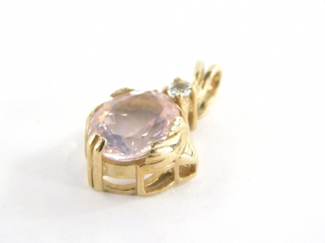 A 9ct gold pendant, with oval cut pink topaz and single cz stone, in a yellow metal mount with twin pendant loop, 2.5cm high, 2.4g all in.