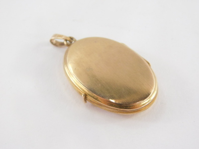 A 9ct gold locket pendant, with leaf scroll detailing and single pendant loop, 2.5cm high, 3.4g. - 2