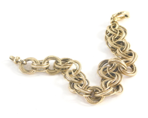 A 9ct gold multi link bracelet, each link comprising three loops, one with twist detailing, the two outer with plain design, on a circular loop clasp, 20.5cm long, 12.3g.