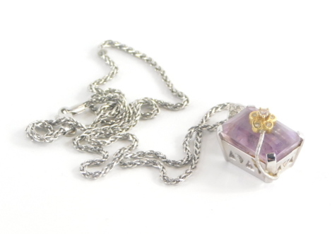 A topaz set pendant and chain, the rectangular cut pink topaz in a raised basket white gold setting, with an arched flower section set with tiny diamonds, white metal unmarked believed to be 18ct white gold, 3cm high on a fancy link chain 50cm long, stamp