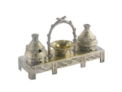 A late 19th/early 20thC novelty silver plated cruet stand, the condiment pot and pepper pot cast in the form of beehives, the central compartment formed in the shape of a two handled basket, on a rectangular stand, the base 10cm x 6cm.