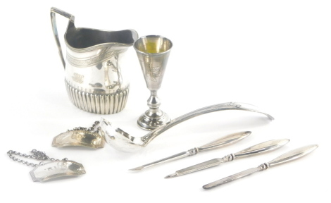 A collection of small silver and silver plated items, to include gin and rum decanter labels, Birmingham 1967, a three piece silver handled manicure set, a silver plated cream jug, a silver liqueur goblet with bright cut decoration, etc. weighable silver 