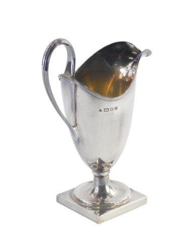 An Elizabeth II silver helmet shaped cream jug, by CSR Ltd, of plain form on a square base, London 1972, 4¾oz, 17cm high.