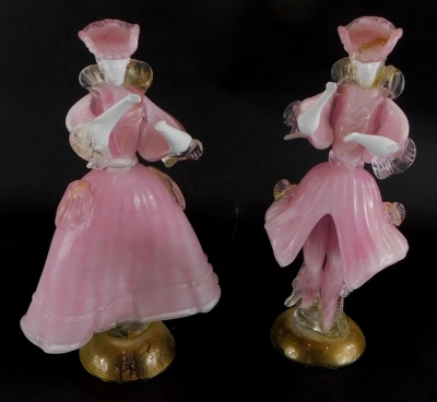 A pair of Murano Italian glass figurines, depicting a lady and gentleman each wearing pink costume, on a domed foot with gold inclusions, labelled to reverse Made In New Art 90 (1AF), 31cm high.