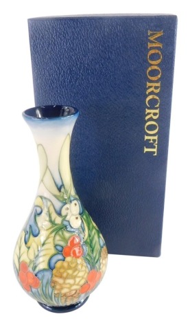A Moorcroft bottle shaped vase, decorated with holly, limited edition number 26/150, made for the Moorcroft Collectors Club, 17cm high, boxed.