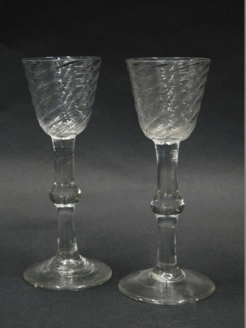 A pair of late 18thC/ early 19thC wine glasses, each with a bell shaped wrythen bowl, and a knopped stem, 16.5cm high. (AF)