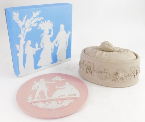 A Wedgwood Jasperware pie dish and cover, in stone coloured matte glaze, with a cauliflower shaped finial, the body decorated with leaves, vines, grapes etc., and a Wedgwood pink Jasperware commemorative plaque, decorated with neoclassical figures and dat