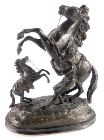 A bronzed spelter figure group, Marley horse with attendant and small horse on oval base stamped France, 41cm high.