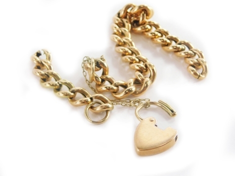A 9ct gold curb link charm bracelet, with safety chain and heart shaped padlock, the chain 17cm long, with loose links (AF), 15.4g all in.