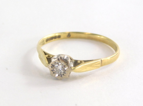 An 18ct gold dress ring, with central round brilliant cut diamond in illusion setting, on raised shoulders on a plain band, hallmarked 18ct, ring size Q, 2.3g all in.