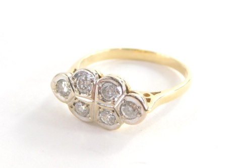 An Art Deco diamond dress ring, set in two three leaf design, each set with tiny diamond, in a white metal setting, on a yellow metal band, unmarked, ring size K, with pierced shoulders, 3.3g all in.