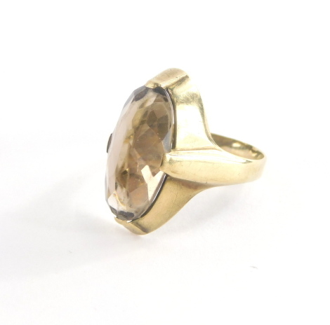 A dress ring, with oval cut and faceted smoky quartz, in a yellow metal setting stamped 333, ring size O½, 3.5g all in.