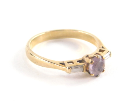 A 9ct gold dress ring, set with oval cut central amethyst in claw setting with two baguette cut cz stone shoulders, in a raised setting on a plain band, ring size Q½, 2.8g all in.