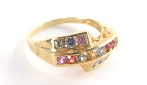 A 9ct gold multi stone dress ring, of three layered design set with pink, red, green, yellow, blue and purple semi precious stones, on a pierced design shank, ring size O½, 3.1g all in.