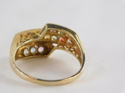 A 9ct gold multi stone dress ring, of three layered design set with pink, red, green, yellow, blue and purple semi precious stones, on a pierced design shank, ring size O½, 3.1g all in. - 2